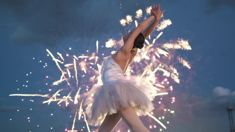 Ballerina dancing amazing ballet celabrating fireworks night city. Girl dancers. Performance dance celebration. Glow sparkling fire work. Pirouette ballerinas dancer. Colorful sparkling woman ballet.