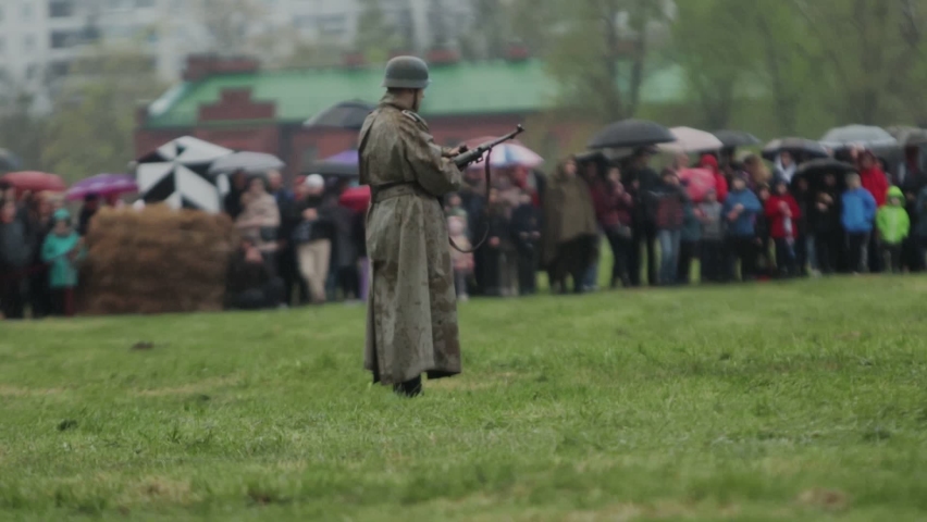 Soldier in uniform of Wehrmacht of German army during World War II stands with maschinenpistole MP 40 gun during reconstruction of invasion to USSR 22 June 1941 on Eastern front against Soviet Union