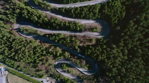 Aerial: Bratocea Pass in Romania, winding mountain road hairpins, top down view