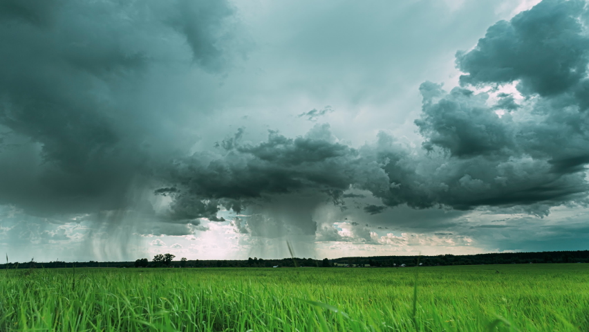 Rain Rainy Clouds Above Countryside Rural Field Landscape With Young Green Wheat Sprouts In Spring Summer Cloudy Day. Heavy Clouds Above Agricultural Field. Young Wheat Shoots 4K time-lapse, timelapse | Shutterstock HD Video #1076796422