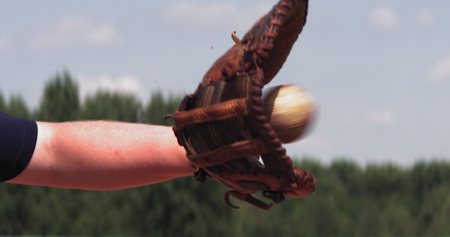 Super slow motion shot of Caucasian teenager baseball player catching a ball outside. Shot with high speed video camera at 420 FPS
