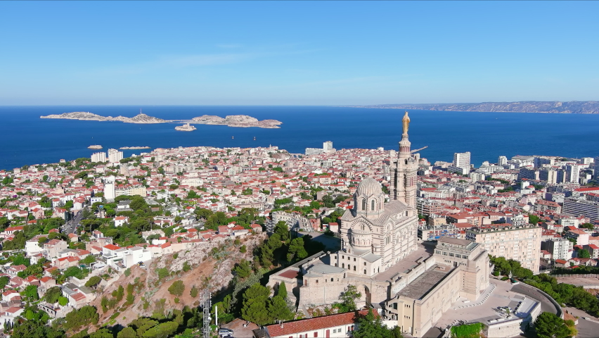 Marseille: Aerial view of city in France, basilica Basilique Notre-Dame de la Garde (la Bonne-mère) on top of hill - landscape panorama of Europe from above Royalty-Free Stock Footage #1076807027