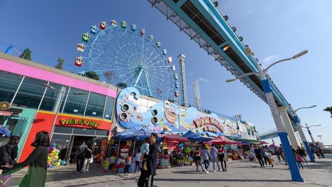 Incheon, South Korea - Oct 12 2019 : Time-lapse of Tourists traveling in Wolmi theme park with sky train and ferris wheel on Wolmido island