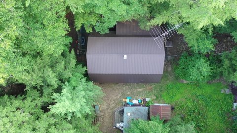 Aerial view of cottage lake house and boats on the water