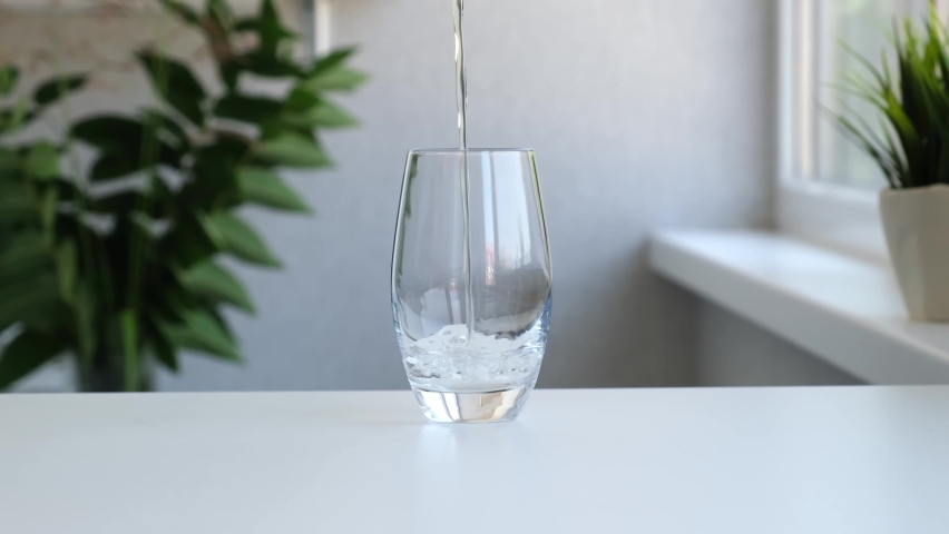 Pure Water Poured Into Glass Closeup. Slow motion. Clear fresh drinking water filling glass. Quenching thirst concept. High quality 4k footage Royalty-Free Stock Footage #1076809856