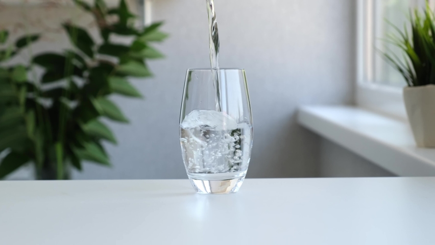 Pure Water Poured Into Glass Closeup. Slow motion. Clear fresh drinking water filling glass. Quenching thirst concept. High quality 4k footage Royalty-Free Stock Footage #1076809856