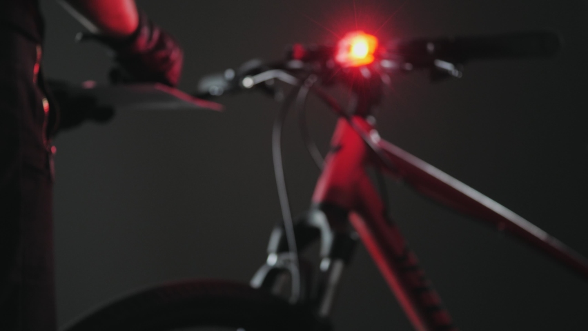 Silhouette of a bicycle policeman in blur. A patrolman stands by a bicycle with a blue-red beacon and fills out the protocol. Royalty-Free Stock Footage #1076811842