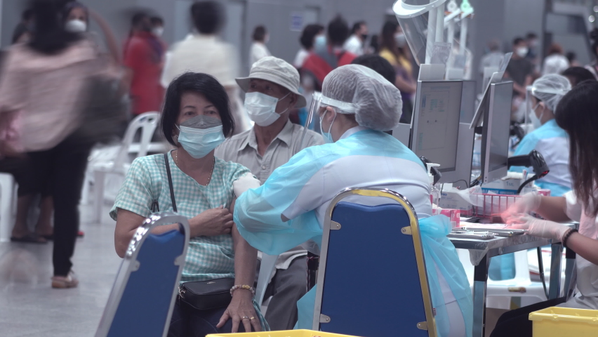 Bangkok, Thailand. 31th July 2021. Timelapse of medical nurse in Protective Mask injects a dose of vaccine into the arm of Patient during corona virus, covid 19 outbreak epidemic.