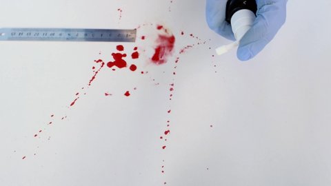 evidence idfresh splatter of red blood on white table, test tube with a sample for examination, forensic expert examines surfaces, collects evidence, forensic medical examiner work concept