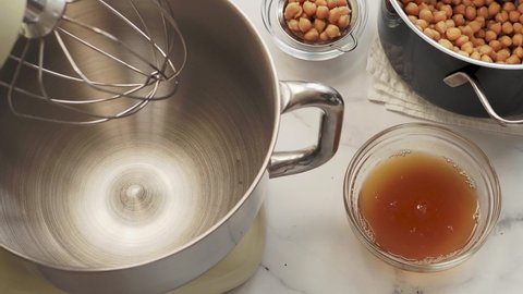 Whipping process chickpea aquafaba in planetary mixer. Accelerated video. 4k. Whole process from start to finish. Chickpea water brine aquafaba whipped. Egg replacement. Vegan concept. Top view