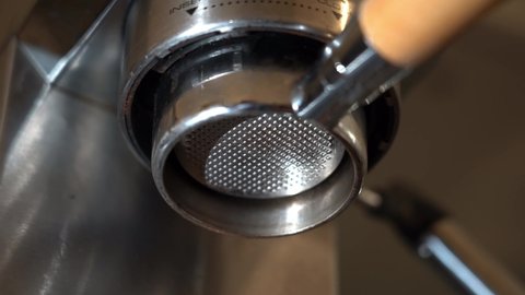 Coffee being extracted through bottomless portafilter from espresso machine. Isolated.