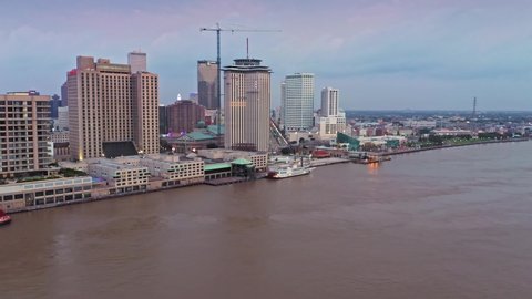 Aerial: Mississippi River waterfront and downtown city skyline. New Orleans, Louisiana, USA. 24 June 2020