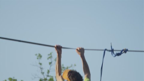 CLOSE UP of mans feet balancing on a slackline and falling off