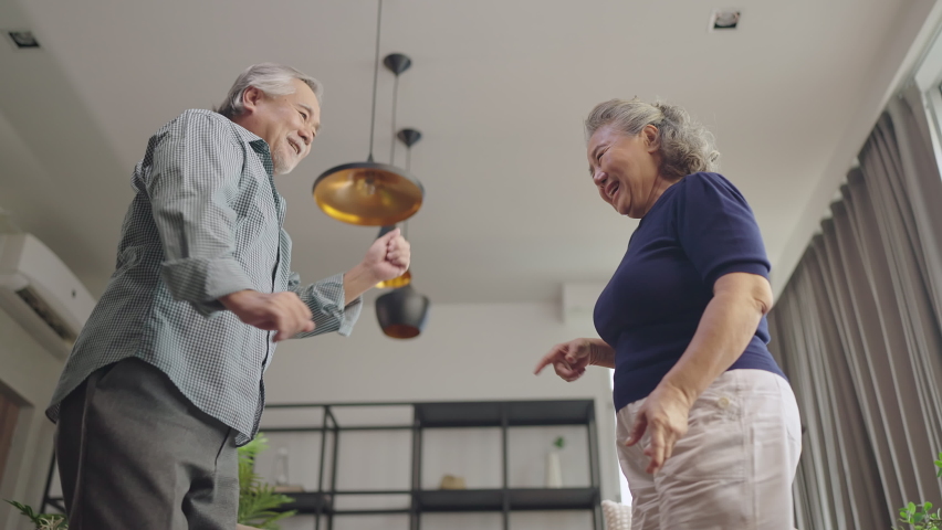 asian senior happiness couple home isolation concept,asian old retired adult couple dancing together at living room with cheerful and joyful moment ,Lovely senior couple dancing at home Royalty-Free Stock Footage #1076865050