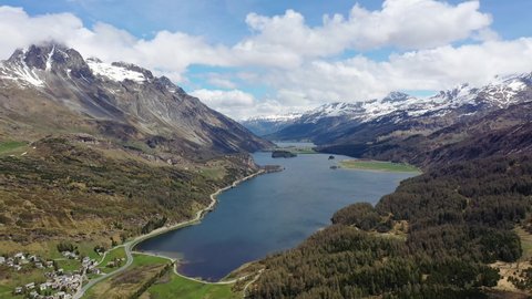 Aerial drone footage of Lake Sils in the Engadin valley in the alps in Canton Graubunden in Switzerland on a sunny summer day. Shot with a rotation motion. 