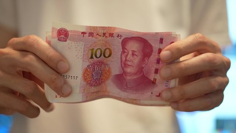 Young money holding lots of Chinese yuan banknote. Investor with cash. Business investment and stock market concept b-roll footage. Man holding money happily. Happy thriving mood video