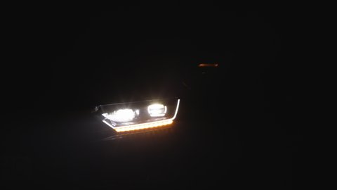 Close up of details of switched on led lights of anonymous prestigious luxury modern car. Car flashing light with blinking indicator. Car Blinker Light, car light blinking on continuously.
