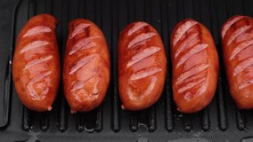 fried sausages on grill top view. Grill sausages. Sliding shot. 4K UHD video