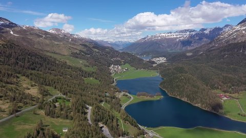 Aerial drone footage of Lake Silvaplana in the Engadin valley in the alps in Canton Graubunden in Switzerland on a sunny summer day. Shot with a rotation motion. 