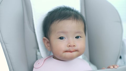 Adorable Asian baby girl happy to eating food feeding by parents 