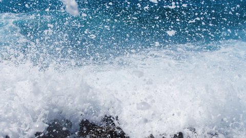 Sea storm concept, 4k landscape footage of ocean blue water and rocks, Sunny daytime seascape, Devastating and spectacular, ocean waves crash on the rocks of the coast creating an explosion of water
