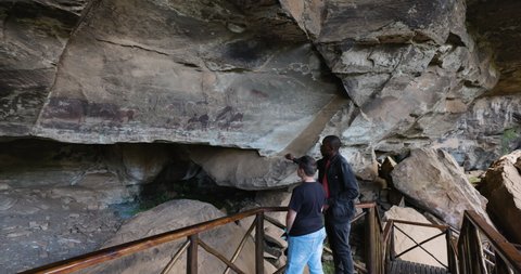 AFRICA,SOUTH AFRICA,CIRCA 2021. Guide showing a tourist the well preserved San bushman paintings in the Main caves at Giants Castle,Drakensberg, KwaZulu-Natal,South Africa
