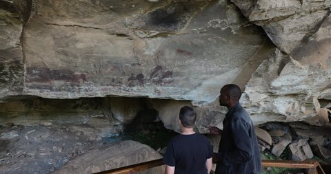 AFRICA,SOUTH AFRICA,CIRCA 2021. Guide showing a tourist the well preserved San bushman paintings in the Main caves at Giants Castle,Drakensberg, KwaZulu-Natal,South Africa