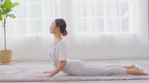 Wellness Attractive Asian woman practice yoga Cobra pose at home to meditation comfortable and relax,Calm of healthy young woman deep breath and meditation with yoga at home,Yoga Concept