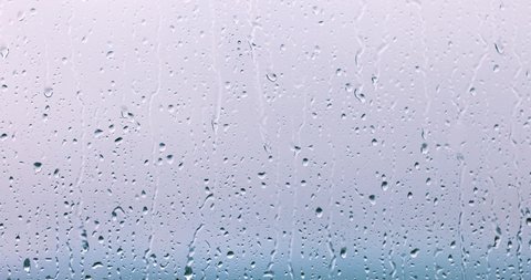 rain drops runnin down the window glass at rainy day