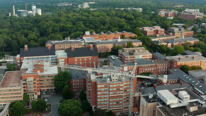 Crane at construction site. Aerial orbit at college university campus in USA.