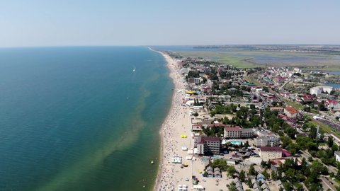Drone view of Zatoka in Odessa. People are resting on a sandy beach near the sea. People sunbathe and swim on the Black Sea in Odessa. Summer rest. Vacation at sea. Relaxation by the clean sea. 
