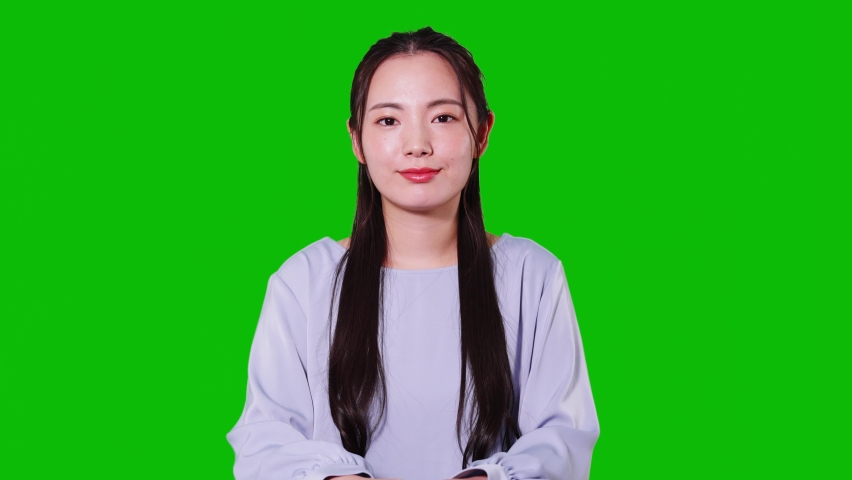 Young asian woman taking video calling. Green background for chroma key composition. | Shutterstock HD Video #1076933336