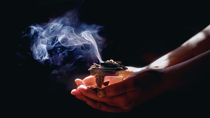 incense in a woman hand, incense smoke on a black background. Royalty-Free Stock Footage #1076936795