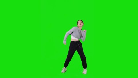 Dancing young asian woman. Green background for chroma key composition.