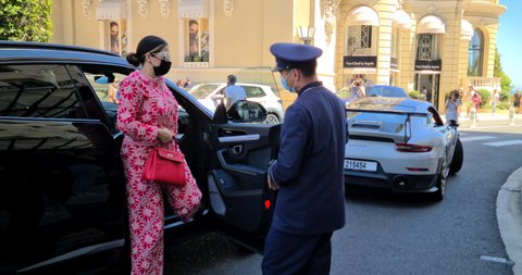 Monte-Carlo, Monaco - August 1, 2021: Male Valet Opening Luxury SUV Door For A Rich Woman In Front Of The Hotel De Paris In Monte-Carlo, Monaco On The French Riviera, Europe - DCi 4K Video