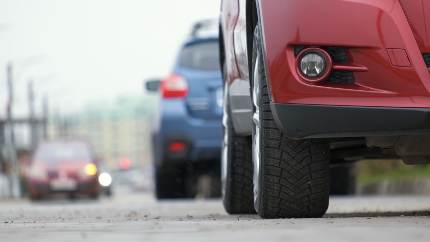Closeup of parked car on a city street side with new winter rubber tires.