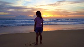 Silhouette Asian teen girl 7 years old standing on beach at sunset raising arms on beach enjoying Amazing sunset or sunrise on summer travel vacation holiday Happiness travel and bliss concept video
