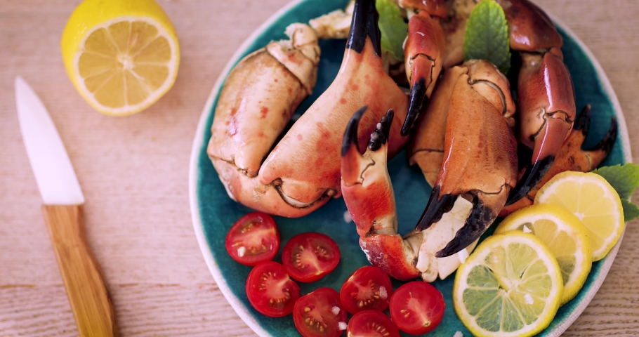cooked and served crab claws with cherry tomatoes and lemons, mediterranean seafood cuisine