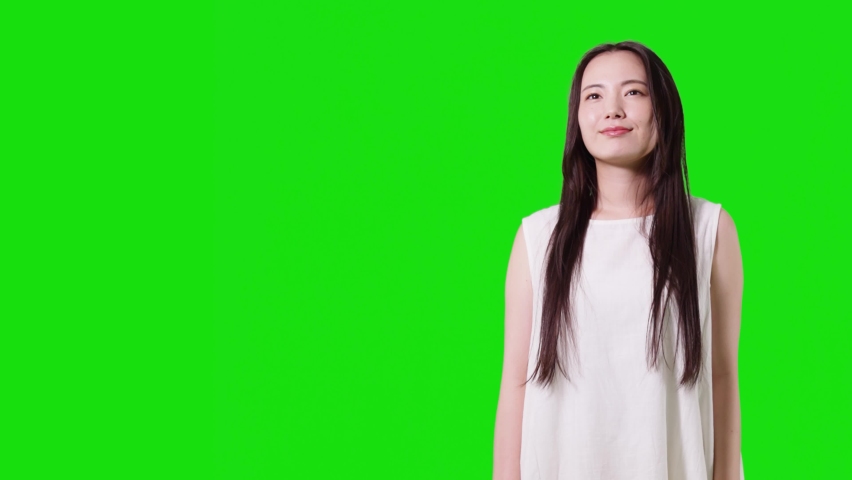 Young asian woman with white dress. Green background for chroma key composition.
