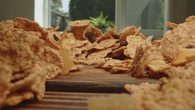 Macro zoom in video of corn flakes on wooden board