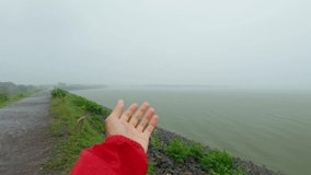 4k video of hand in front of lake feeling rain drops falling on palm during rainfall in monsoon season