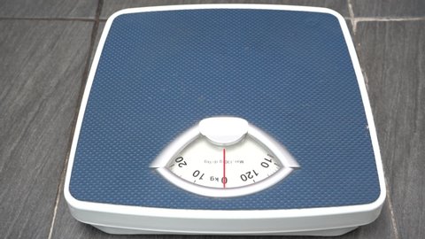 Parents are weighing with an analog scale to ensure the ideal weight in old age who are prone to disease.
