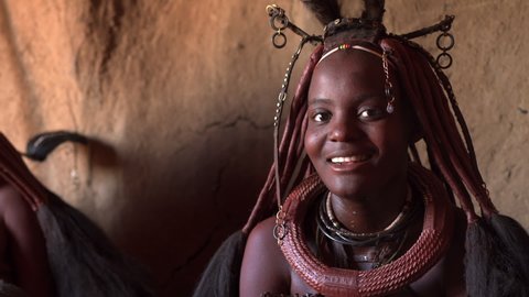 Young Himba woman inside her hut at traditional Himba village near Kamanjab in Namibia, Africa.