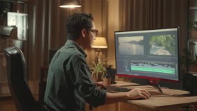 Asian Male Video Editor Works With Footage And Sound On His Personal Computer, He Works Late At Night

