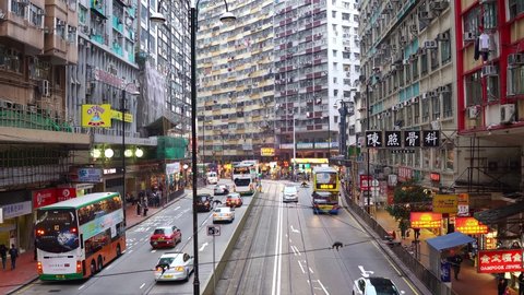 North Point, Hong Kong - January 24 2019: Time lapse of cars, buses and traditional tramway car that rush along the King's road in North Point very densely populated district in Hong Kong island