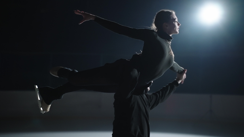 Professional skaters in the counter-turns a pair of men and women perform a rotation, the man lifts the girl on the arm and spins together on skates in slow motion Royalty-Free Stock Footage #1076966639