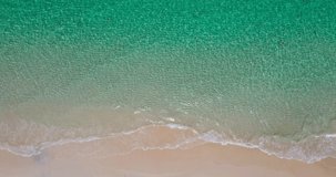 Beautiful beach Aerial view shot of drone. Top-down view full frame beach sand and water texture and clear. Nature and travel concept. 4K UHD Video clip.