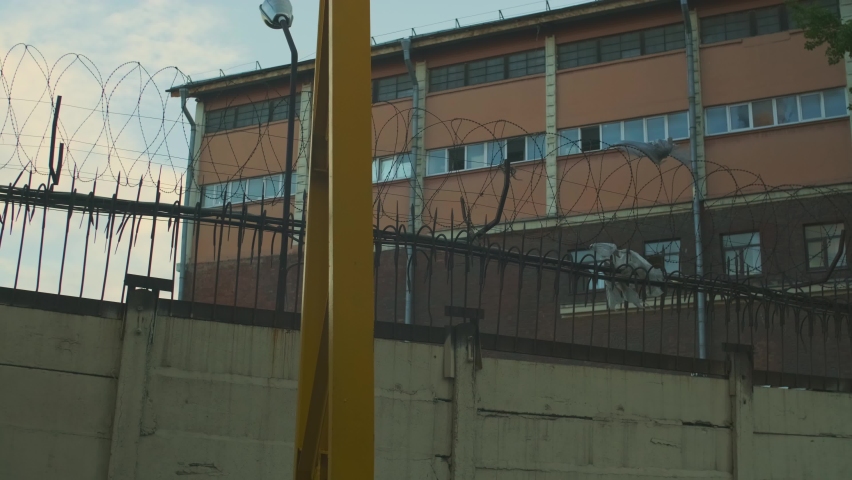 Razor wire. Barbed wire fence with sharp spears - no trespass. Prison, jail view. Declared guilty people. That prisoners can see: light blue sky and rare clouds. Crime, crackdown, illegal concept  Royalty-Free Stock Footage #1076982305
