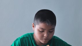 A Child boy is having lunch. Front view in Medium close up shot. This clip was 24 fps.