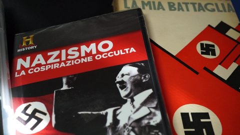 Rome, Italy - August 01, 2021, detail of a collection of CD documents and books on the history of Nazism and Fascism with the main protagonists of Adolf Hitler and Benito Mussolini.